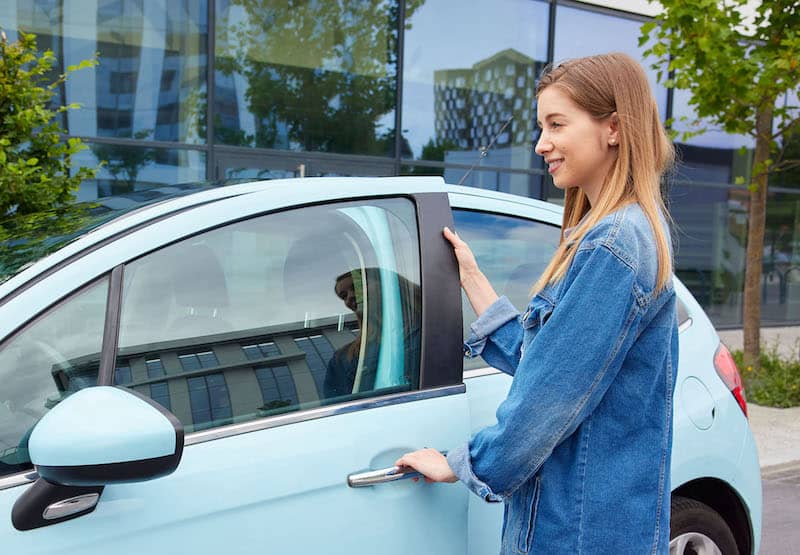 Illustration d'une femme ouvrant la portière de sa voiture