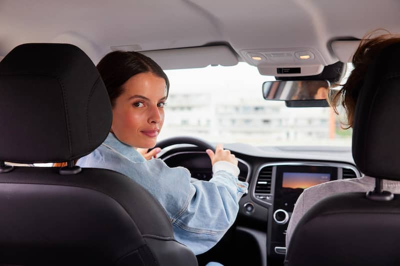 Illustration d'une femme au volant, regardant derrière